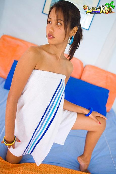 Brown Thai cutie Lily Koh wearing only a towel and shy smile
